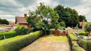 A paved courtyard with a small table and benches, surrounded by neatly trimmed hedges and trees. - Strelley House 4 - free parking, WiFi , Netflix, Family & Contractor friendly (Nottingham)