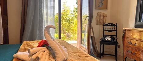 A room with a bed, a wooden dresser, a chair, and a painting on the wall.