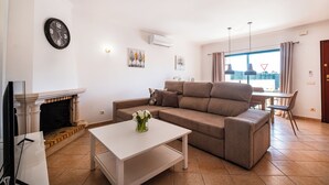 Un salon avec une cheminée, un canapé, une table basse et un coin repas offrant une vue agréable.