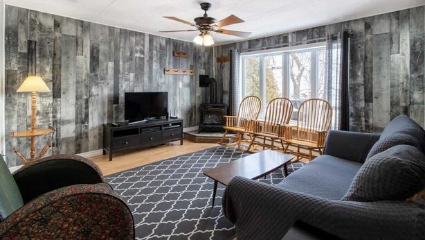 Una sala de estar con chimenea, televisor y zona de estar.
