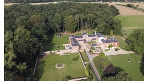 Een groot landgoed met meerdere gebouwen, een centrale binnenplaats en omliggend groen.