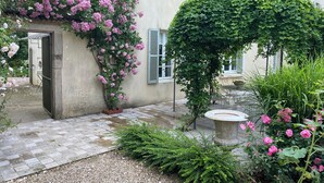 A garden with a pergola covered in climbing plants, a stone bench, and a gravel pathway leading to a door. - 19th century manor house "la belle vie" 14/15 persons 5 min from Beaune (Tailly)