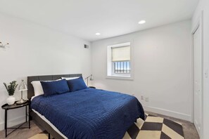 A bedroom with a bed, bedside table, lamp, window, and a view of the sky. - Free Parking! Large, 2BR/1.5BA with AC/TV/Internet (Washington)