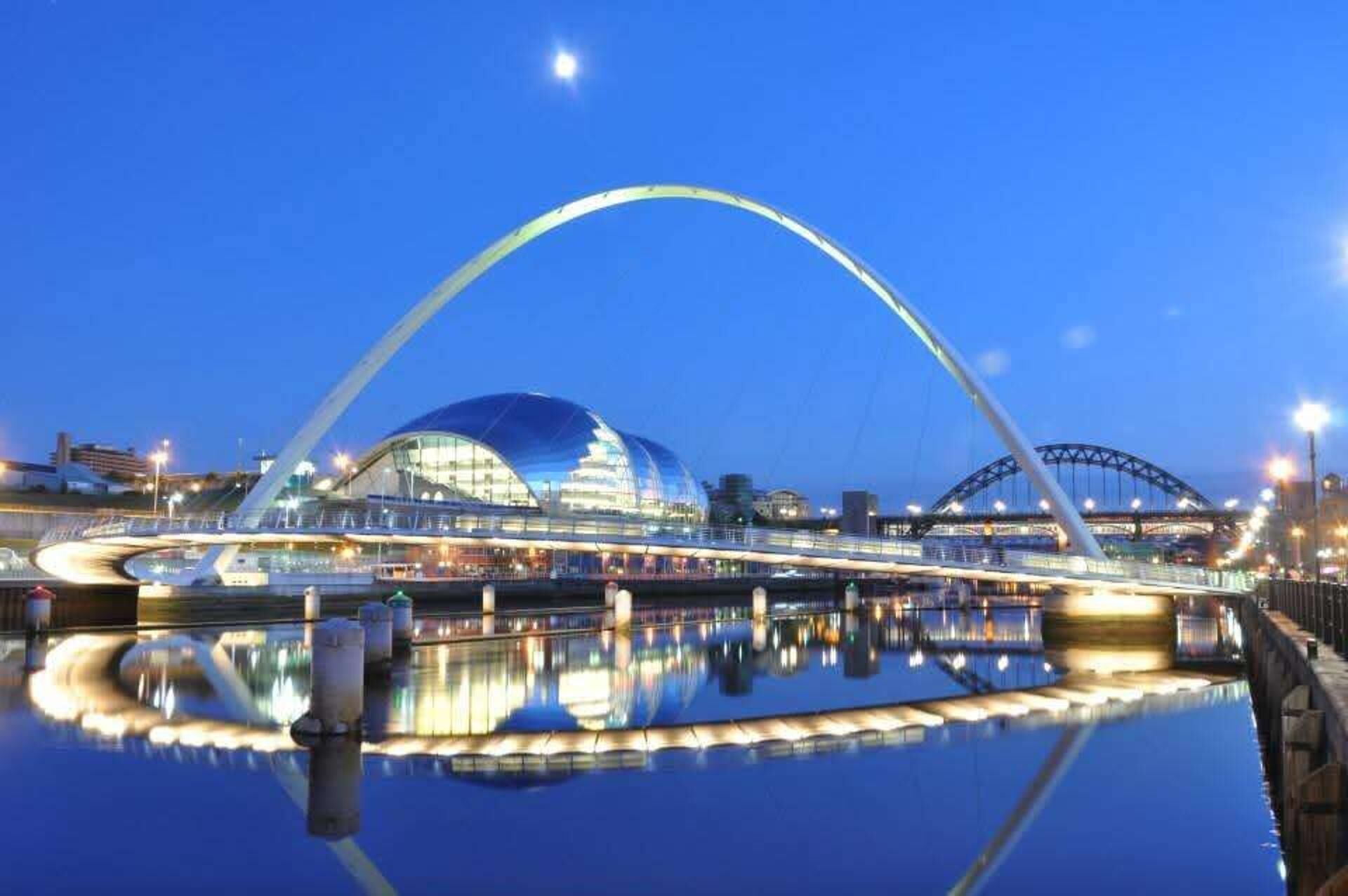 A modern bridge with a glass structure and a large, arched design.