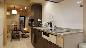A modern kitchen with a built-in dishwasher, a microwave, and a sink. There is a dining area with a table and chairs.