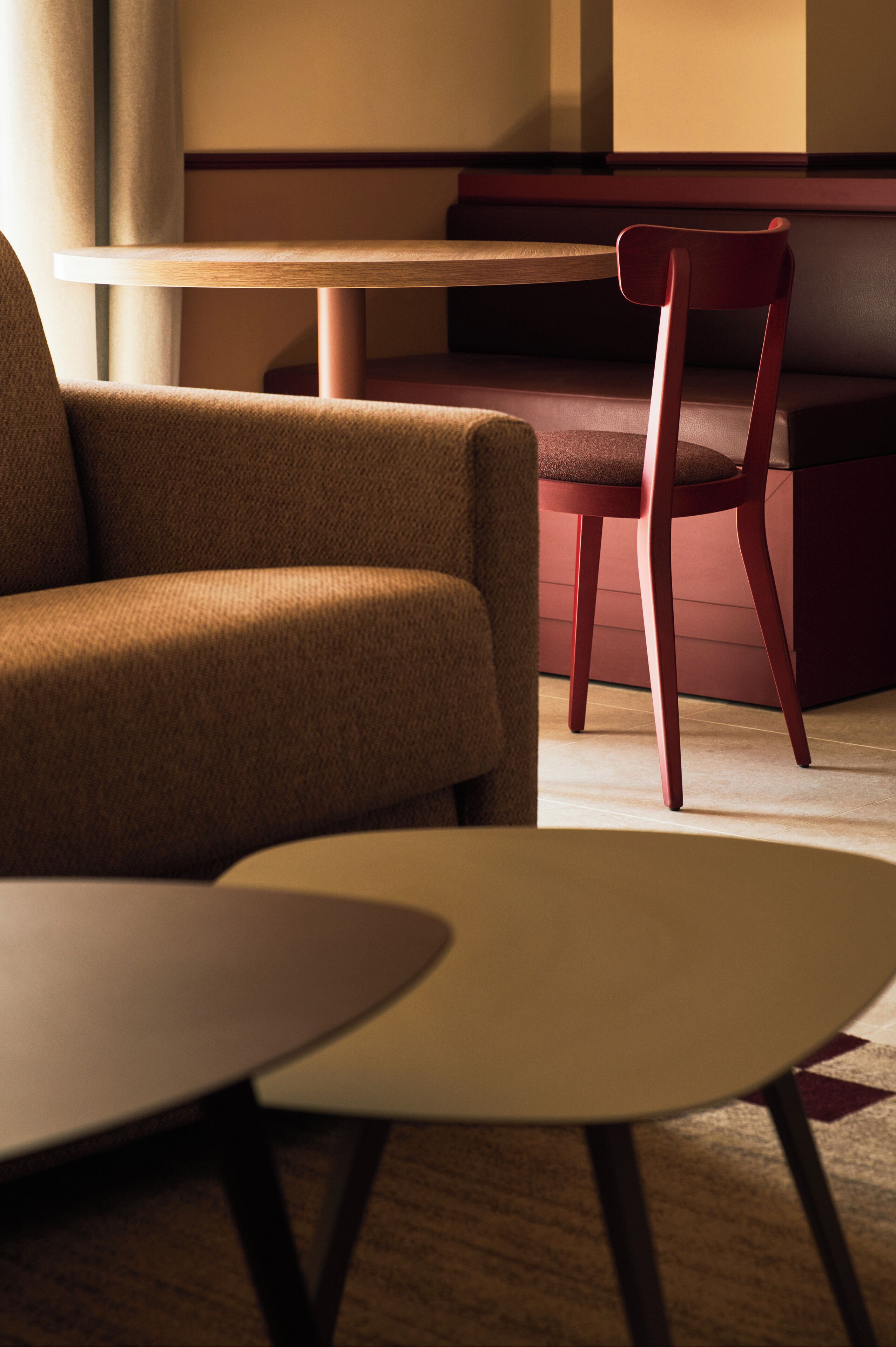 Un interior moderno con una mesa redonda y una silla acolchada.