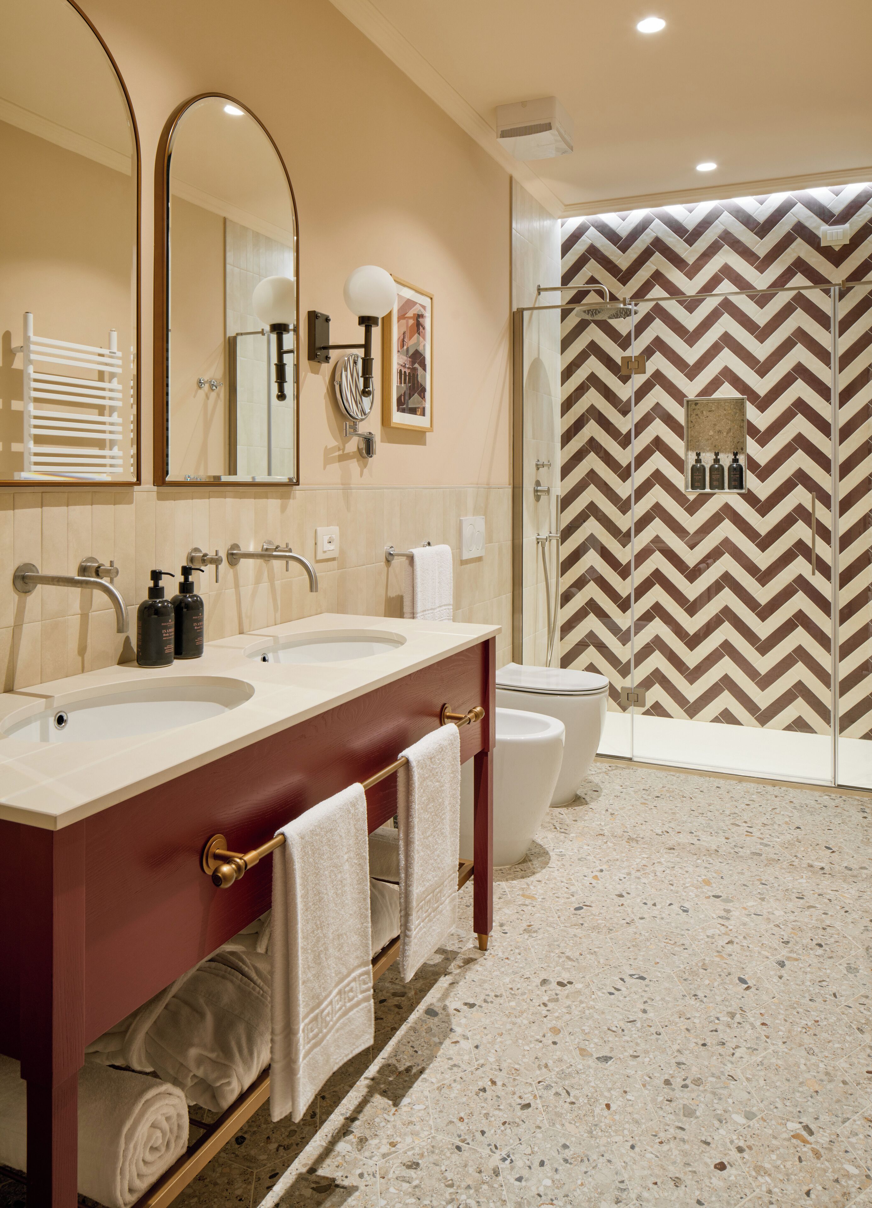 A modern bathroom with two sinks, a large mirror, and a shower area.