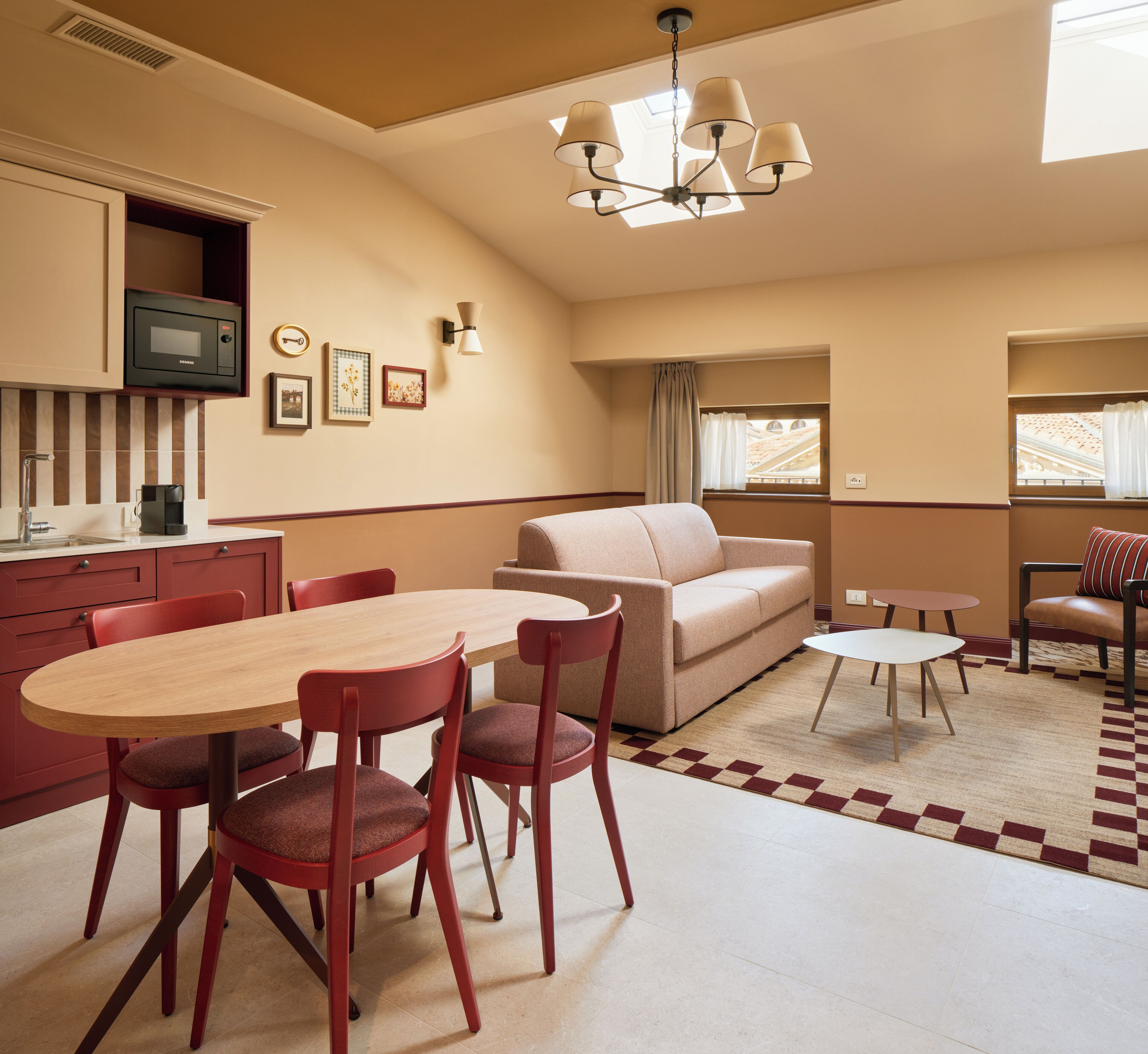 Une chambre d’hôtel moderne comprenant un coin repas, un canapé, une petite table et un téléviseur.