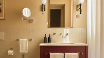 Une salle de bain équipée d’un bidet, d’un lavabo avec deux miroirs et d’un porte-serviettes.