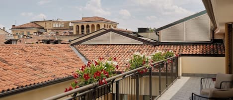 A balcony with a tiled floor, a metal railing, and a red mat with 'HOMW' on it.