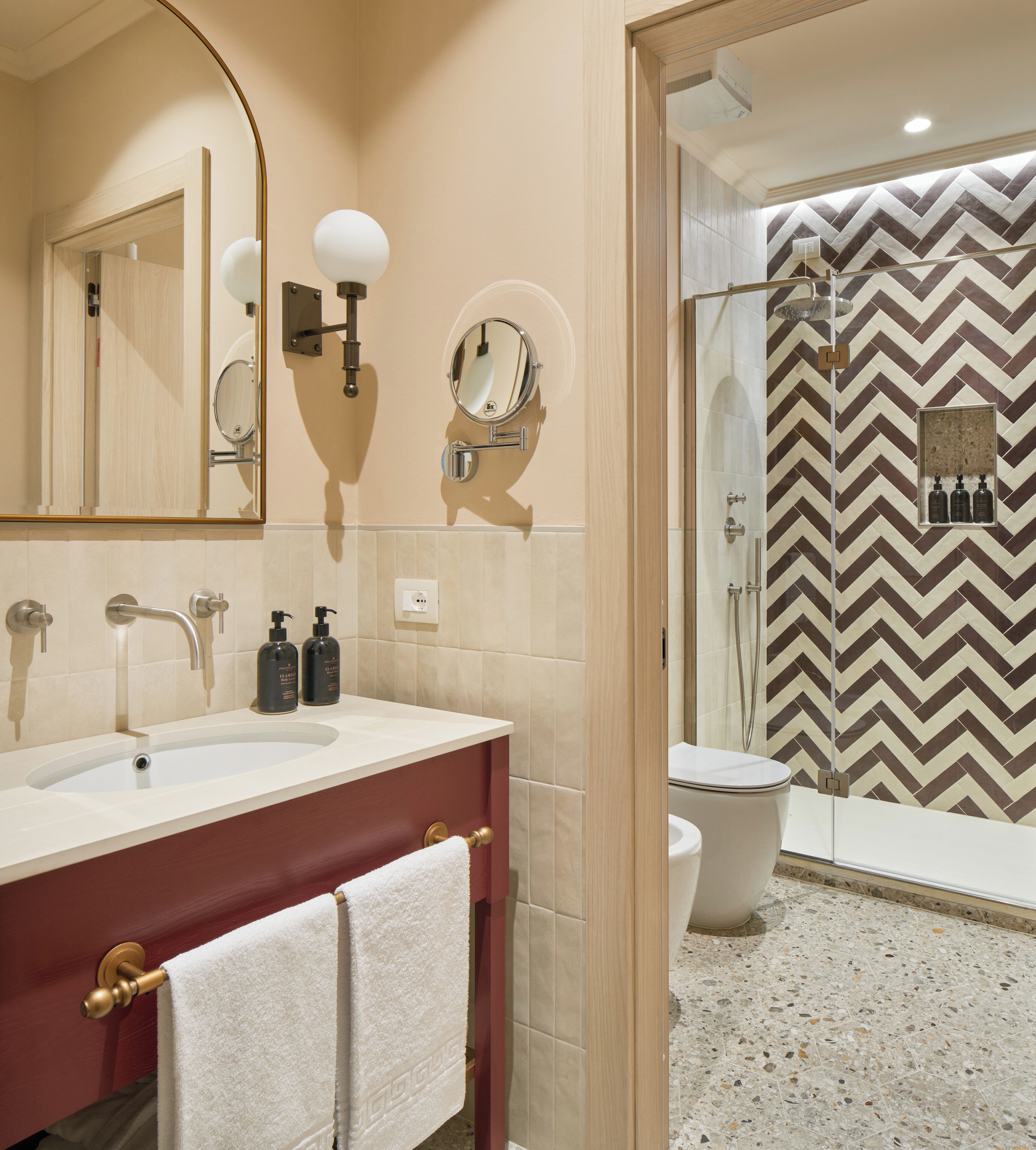 A modern bathroom with a vanity, mirror, and shower.