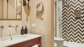 A modern bathroom with a vanity, mirror, and shower.