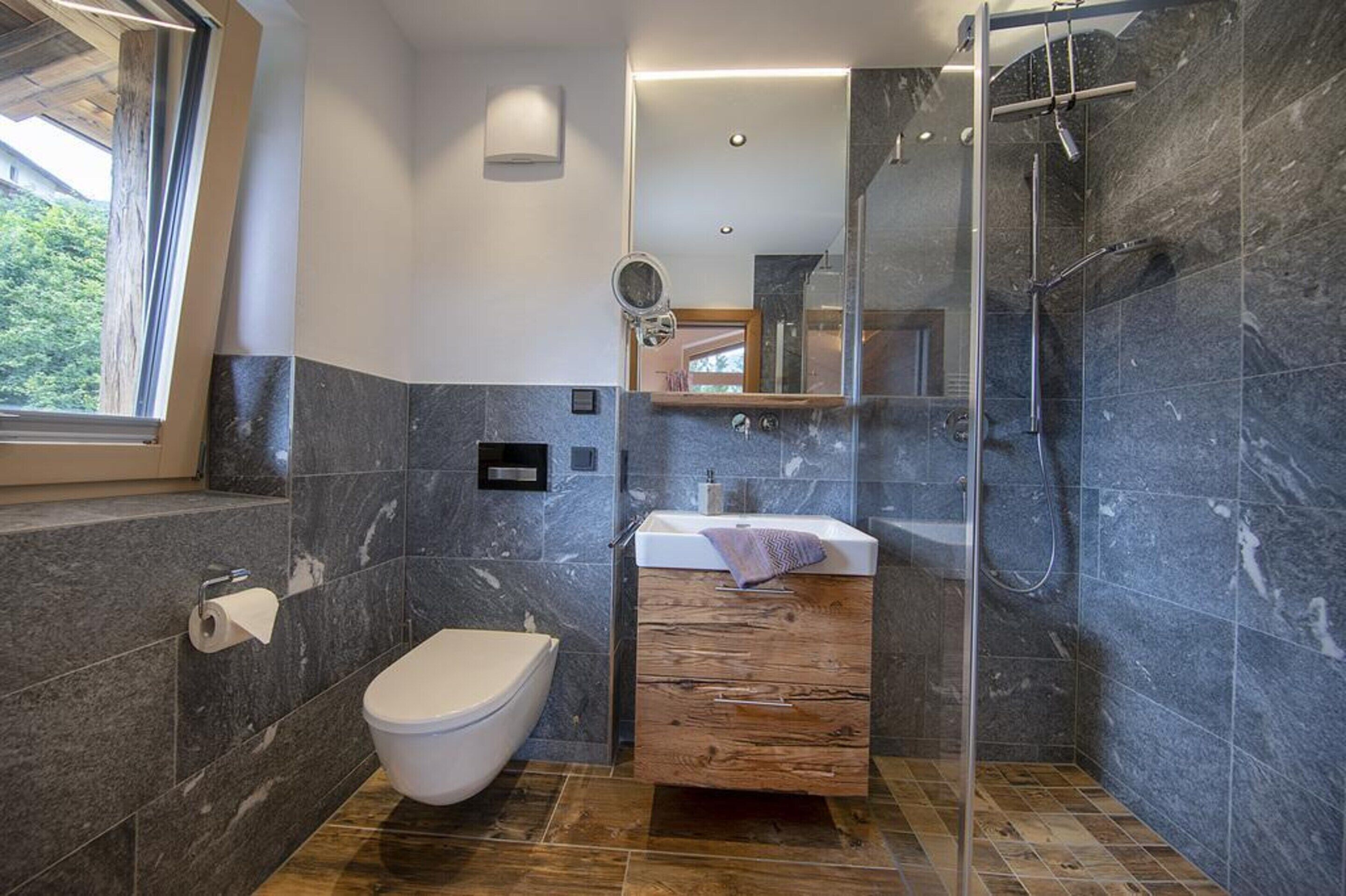 A modern bathroom with a toilet, sink, and shower.