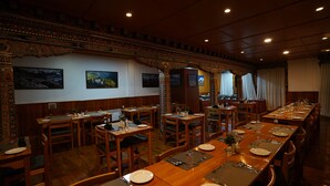 Un restaurante con mesas y sillas de madera, decorado con motivos tradicionales.