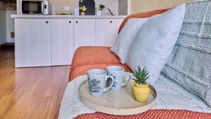 A cozy living area with a sofa, two coffee mugs on a tray, and a small potted plant. - Lake Maggiore - Elegant Apartment with Pool (Euroville)