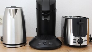 Three kitchen appliances: a stainless steel kettle, a black coffee maker, and a silver toaster. - 90 sqm apartment suitable for family (Bad Soden am Taunus)