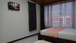 A bedroom with a bed, a TV mounted on the wall, and a window with curtains. - Comfortable house to rest in Paipa, excellent location. (Paipa)