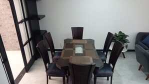 A dining area with a rectangular table surrounded by six chairs, a potted plant, and a sofa. - Comfortable house to rest in Paipa, excellent location. (Paipa)