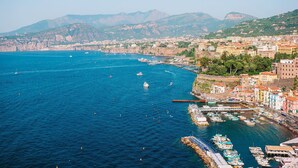 A coastal town with a marina, boats, and buildings along the waterfront. - Casa Oscar - My Rental Homes (Marciano)