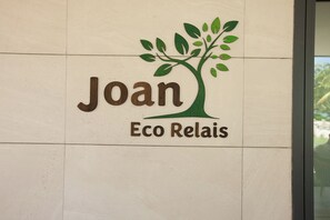 Logotipo con el nombre 'Joan Eco Relais' y un gráfico de un árbol.