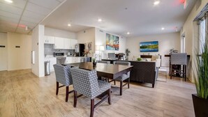 A modern kitchen with white cabinets, a central island, and a dining area with patterned chairs. - Stunning 1Bd/1Bth I Properties by Preston (San Antonio)