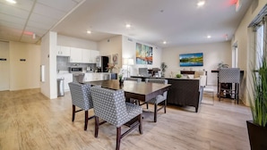 A modern kitchen with white cabinets, a central island, and a dining area with patterned chairs. - Simplicity At the Rim  1415 I Spacious 1 Bed 1 Bth (San Antonio)