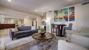 A modern living room with a sofa, armchairs, a coffee table, and abstract wall art. - Simplicity At the Rim 1419 I Spacious 1 Bed 1 Bth (San Antonio)