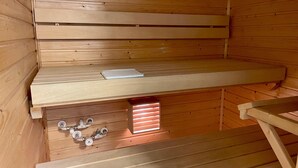 A sauna with wooden benches and a bench with a book. - Kotimaailma KotikaksioKirkkok saunalla (Lahti)