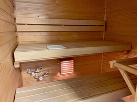 Sauna, jossa on puiset lauteet ja yksi lauteista on varattu lukemista varten.