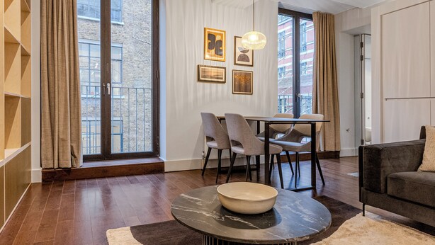 A modern living room with a dining area, large windows, and a view of the city. - Your Apartment - St. Paul's (London)