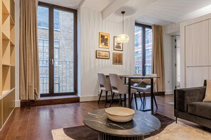 Uma sala de estar moderna com área de jantar, janelas amplas e vista para a cidade.