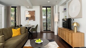 A modern living room with a sofa, dining table, and a TV on a wooden cabinet. - Your Apartment - St. Paul's (London)