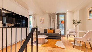 A modern living space with a kitchen, a sofa with cushions, a dining area with chairs, and a staircase. - Your Apartment - St. Paul's (London)