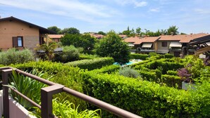 A residential area with a swimming pool surrounded by well-maintained hedges and greenery.