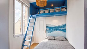Ein Schlafzimmer mit einem Etagenbett, einer Himmelsleiter, einem großen Fenster und einem Wandgemälde.