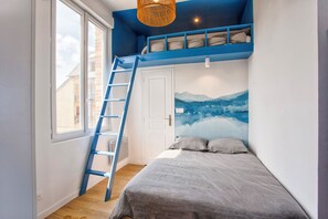 A bedroom with a bunk bed, a ladder, a large window, and a mural on the wall. - Bleu Horizon - Studio with balcony and sea view (Villers-sur-Mer)