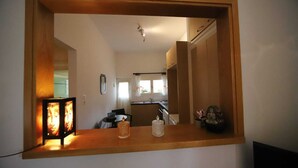 Cuina amb taulell de fusta, un rentaplat i una finestra.