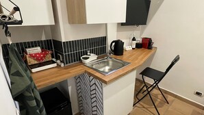 A compact kitchen with a sink, a kettle, a coffee maker, and a small refrigerator. - Casa Amicitia Spanish Steps (Roma)