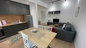 Un espacio habitable compacto con kitchenette, zona de comedor y área de descanso.