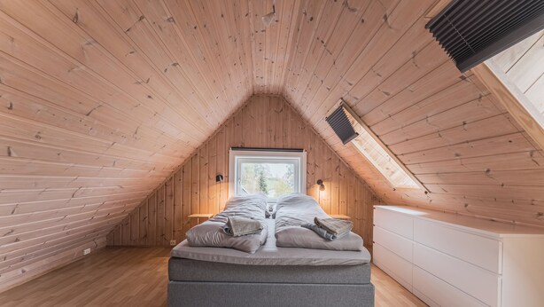 A bedroom with a sloped ceiling, a bed, a window, and a white dresser. - Top-Floor Apartment – 5 Min Walk to Lillehammer’s Main Street (Innlandet)