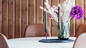 A dining table with a vase of flowers, a candle, and a placemat. - Top-Floor Apartment – 5 Min Walk to Lillehammer’s Main Street (Innlandet)