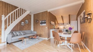 A modern living room with a staircase, a dining area with chairs and a table, and a kitchen area. - Top-Floor Apartment – 5 Min Walk to Lillehammer’s Main Street (Innlandet)