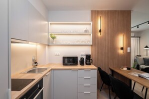 Apartamento design, vista para a cidade | Cozinha privada | Geladeira grande, micro-ondas, fogão, cooktop