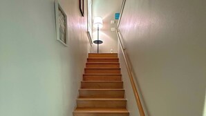 Eine Holztreppe mit Handlauf, die zu einer Zwischenebene führt.