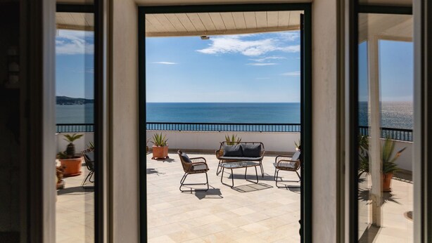 An open balcony with a view of the sea, outdoor furniture, and potted plants. - Casa sul Mare by Rentbeat (Vieste)