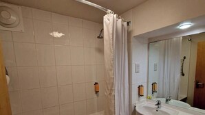 A bathroom with a bathtub, a shower, a sink, and a toilet. - Charter Hotel Bournemouth (Bournemouth)