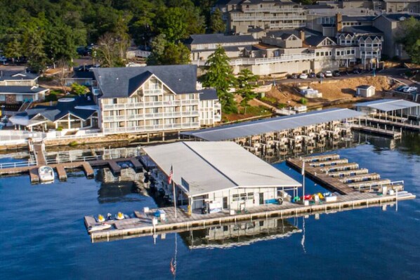 A waterfront hotel with a large building, multiple docks, and boats.