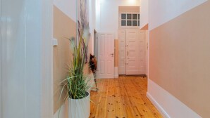 A hallway with wooden flooring, white walls, and a potted plant. - Cosy tiny flat central Berlin Charlottenburg (Berlin)