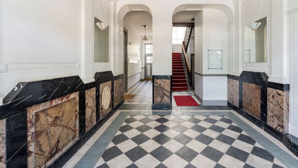 A grand hallway with marble floors and walls, leading to a staircase. - Cosy tiny flat central Berlin Charlottenburg (Berlin)