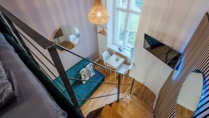 A modern interior with a staircase, a dining area, and a large window providing a view of the outdoors. - Cosy tiny flat central Berlin Charlottenburg (Berlin)